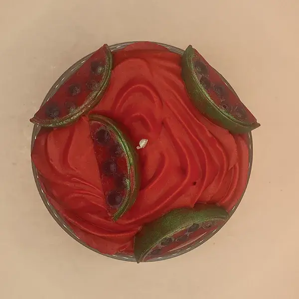 Bougie gourmande parfumée melon pastèque design pastèque rouge haut avec une décoration de fondants parfumée en forme de quart de pastèque